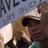-9월 23일 오후 서울역 앞에서 열린 ‘전국 이주노동자 투쟁의 날’ 집회에서 한 이주노동자가 "우리는 노예가 아니다" 라고 적힌 팻말을 들고 있다.