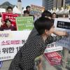 -10월 5일 서울 광화문광장에서 열린 ‘군형법 상 추행 죄 폐지를 위한 1만인 입법청원운동 선포 기자회견’에서 참가자들이 군형법 92조의6을 부수는 퍼포먼스를 하고 있다.